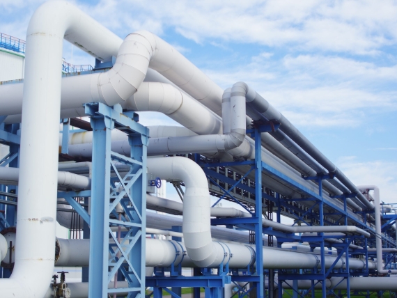 A closeup of industrial pipelines around a factor on a sunny day
