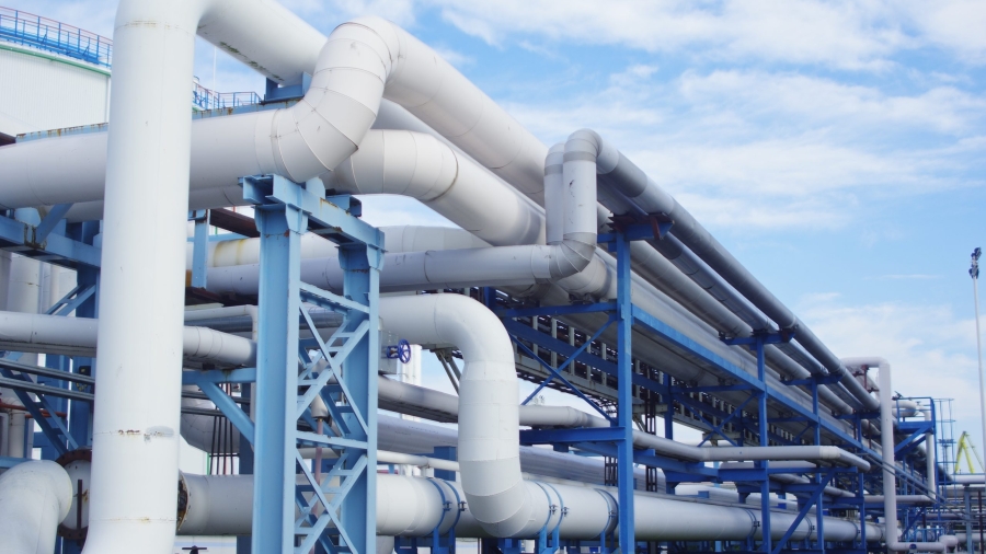 A closeup of industrial pipelines around a factor on a sunny day
